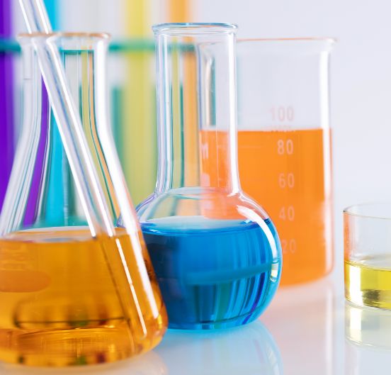 //perspectiwitty.in/kcpl/wp-content/uploads/2023/12/closeup-shot-different-flasks-with-colorful-liquids-white-surface-lab.jpg